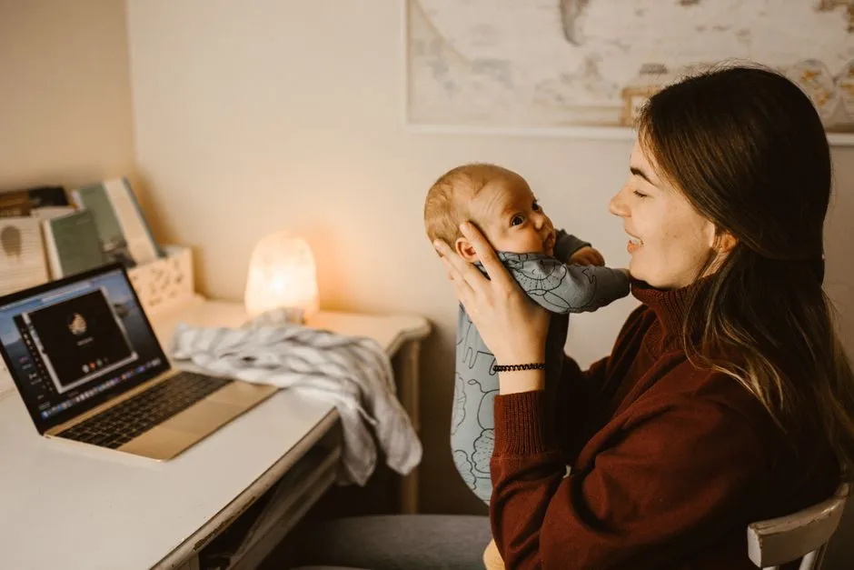 A parent holding a baby while video calling from a home office, illustrating the balancing act of returning to work after parental leave.